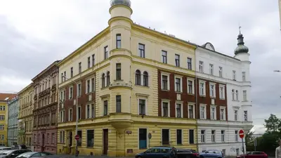 a yellow and white building with cars parked in front of it at METRO Apartment Prague by Main Train and Bus Station in Prague