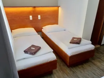 two beds in a room with two bags on them at Beta Pension in Prague