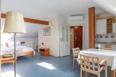 a bedroom with a bed and a table and a kitchen at Sibelius Apartments Prague - Art Nouveau Residence 1902 in Prague