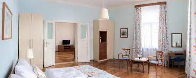 a bedroom with a bed and a table and chairs at Sibelius Apartments Prague - Art Nouveau Residence 1902 in Prague