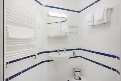 a white bathroom with a sink and a mirror at Sibelius Apartments Prague - Art Nouveau Residence 1902 in Prague