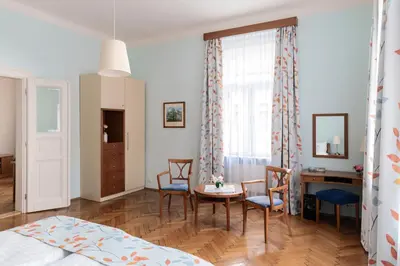 a bedroom with a bed and a table and chairs at Sibelius Apartments Prague - Art Nouveau Residence 1902 in Prague