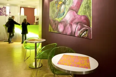 a couple of tables and chairs in a room with a painting at Dahlia Inn in Prague