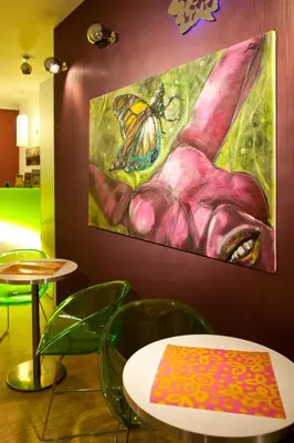 a painting of a butterfly on a flower on a wall at Dahlia Inn in Prague