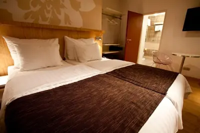 a bedroom with a large bed with white pillows at Dahlia Inn in Prague