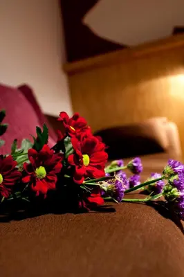 a bouquet of red and purple flowers on a bed at Dahlia Inn in Prague