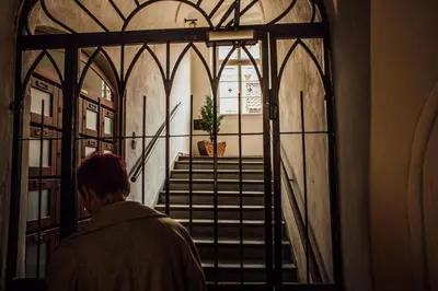 a man looking out of a door into a building at Residence Thunovska in Prague