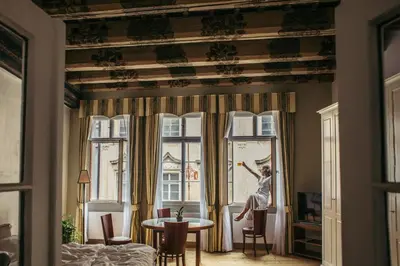 a woman jumping in a window in a room at Residence Thunovska in Prague
