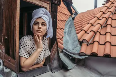 a woman is looking out of a window at Residence Thunovska in Prague