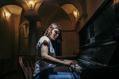 a woman playing a piano in a room at Residence Thunovska in Prague