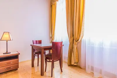 a table and chairs in a room with a window at Residence Thunovska in Prague