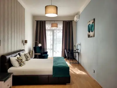 a bedroom with a bed and a large window at GE Apartments in Prague