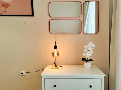 a lamp on a dresser with two mirrors on a wall at GE Apartments in Prague