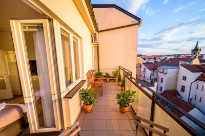 a balcony with potted plants and a view of a city at Michal&Michael’s Central Apartments in Prague
