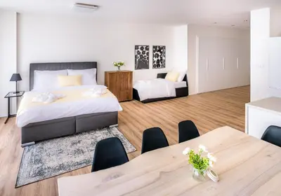 a bedroom with a bed and a table with chairs at Michal&Michael’s Central Apartments in Prague