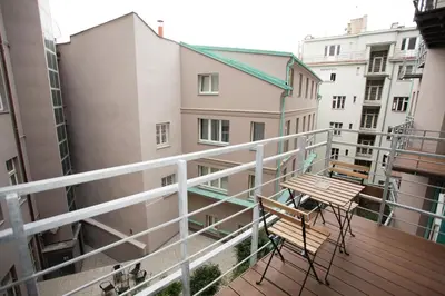 a balcony with a wooden table and chairs on it at Luxury apartment Spálená in Prague