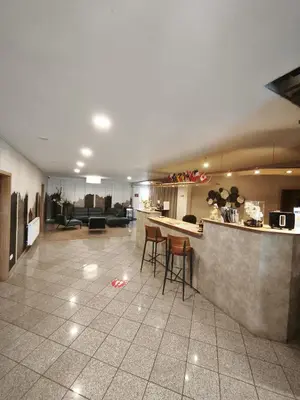 a kitchen and living room with a counter and stools at Penzion Solid Spa in Mladá Boleslav