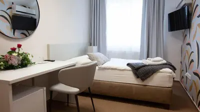 a hotel room with a bed and a desk and a mirror at Penzion Solid Spa in Mladá Boleslav