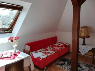 a red couch in a room with a table at Homestay Svatá in Svatá