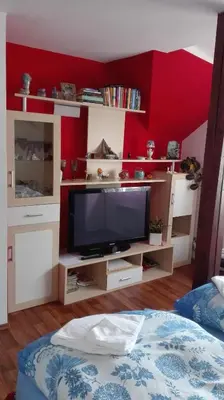 a living room with a tv and a red wall at Homestay Svatá in Svatá