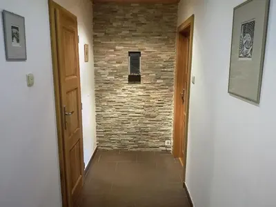 a hallway with a brick wall and a door at Apartment Hanspaulka Garden in Prague