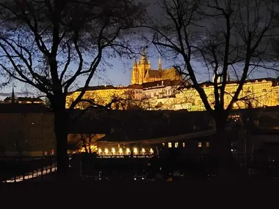 a view of a building at night with trees at Apartment Hanspaulka Garden in Prague
