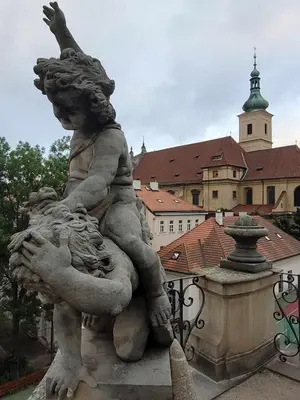 a statue of a girl sitting on top of a building at Apartment Hanspaulka Garden in Prague