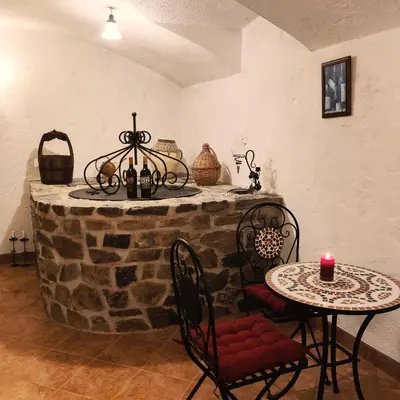 a room with a table and chairs and a stone wall at Penzion Stranny in Stranný