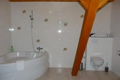 a white bathroom with a tub and a toilet at Penzion Stranny in Stranný