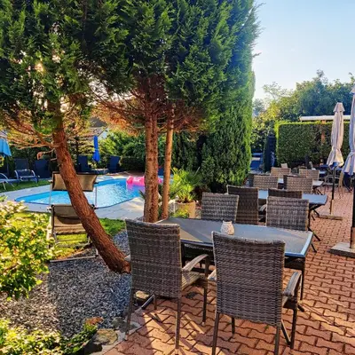 a patio with a table and chairs next to a pool at Penzion Stranny in Stranný