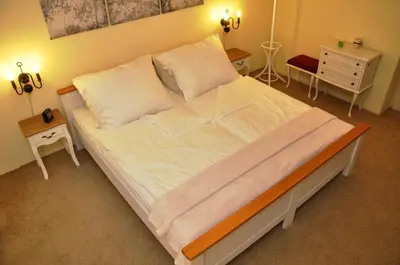 a large bed with white sheets and pillows in a bedroom at Atmospheric Quiet Apartment in Prague
