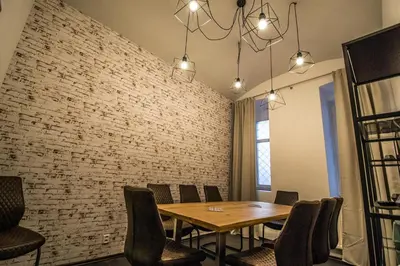 a dining room with a table and a brick wall at Brooklyn Sauna Apt by Ruterra in Prague