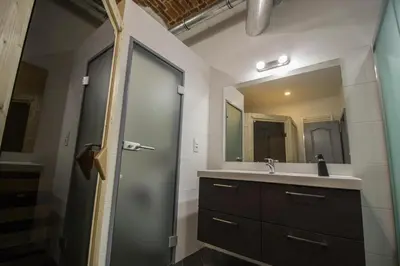 a bathroom with a sink and a shower with a mirror at Brooklyn Sauna Apt by Ruterra in Prague
