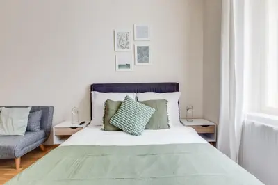 a bedroom with a large bed with green pillows at Modern Quiet Apt next to Wenceslas Square - VS in Prague