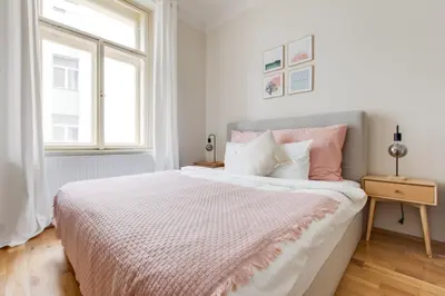 a white bedroom with a large bed with pink pillows at Modern Quiet Apt next to Wenceslas Square - VS in Prague