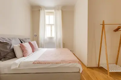 a bedroom with a bed with pink and grey pillows at Modern Quiet Apt next to Wenceslas Square - VS in Prague