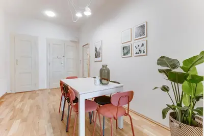 a dining room with a white table and pink chairs at Modern Quiet Apt next to Wenceslas Square - VS in Prague