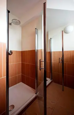a shower with a glass door in a bathroom at Relax Inn in Prague