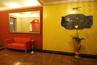 a waiting room with a red chair and a mirror at Relax Inn in Prague