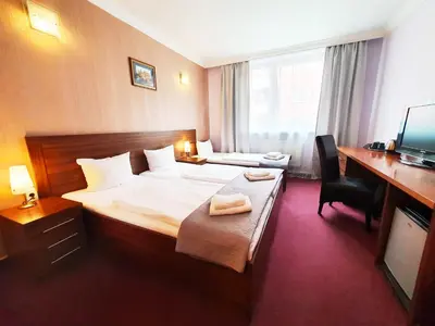 a hotel room with a bed and a desk at Relax Inn in Prague
