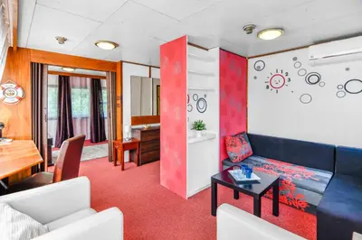 a living room with a blue couch and a table at Botel Vodnik in Prague
