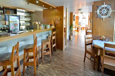 a restaurant with a bar and a table and chairs at Botel Vodnik in Prague