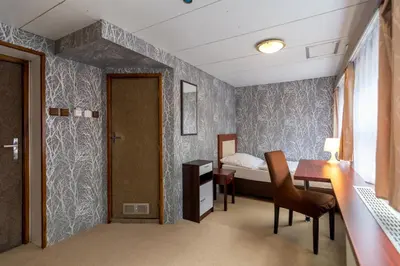 a bedroom with a bed and a desk and a door at Botel Vodnik in Prague