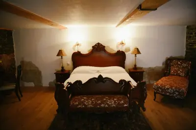 a bedroom with a large bed and a chair at Savoia Castle in Škvorec