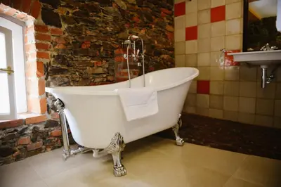 a white bath tub in a bathroom with a sink at Savoia Castle in Škvorec