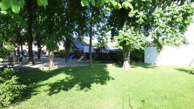 a green yard with trees and a playground at Hotel Svornost in Prague
