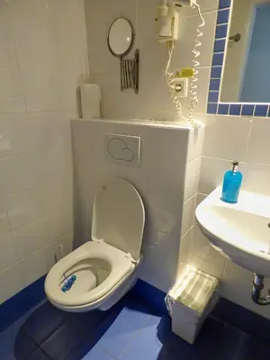 a small bathroom with a toilet and a sink at Hotel Svornost in Prague