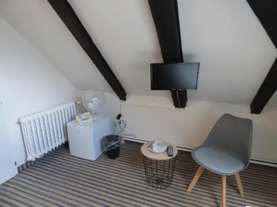 a room with a chair and a tv on the wall at Hotel Svornost in Prague