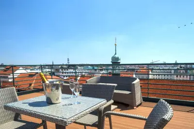 a table with wine glasses on a balcony at Hotel Leon D´Oro in Prague