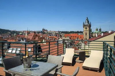 a balcony with tables and chairs and a view of a city at Hotel Leon D´Oro in Prague
